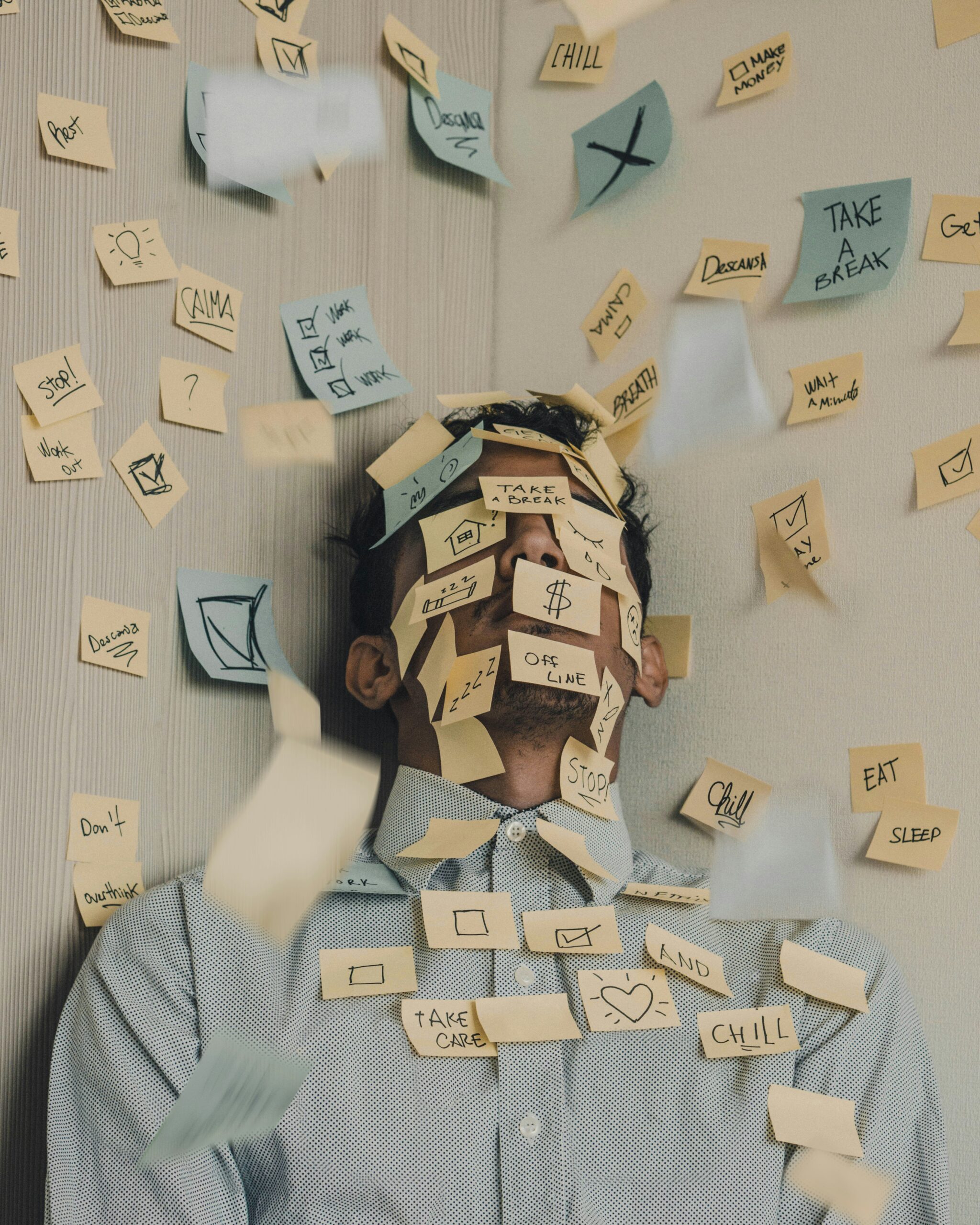 Person fühlt sich von zu vielen To do's auf Post-its überfordert